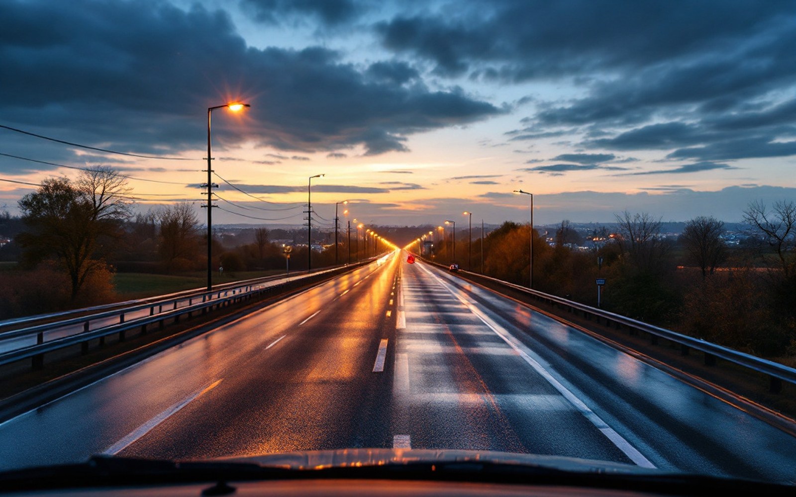 A road leaving a motorway toward a town at dusk